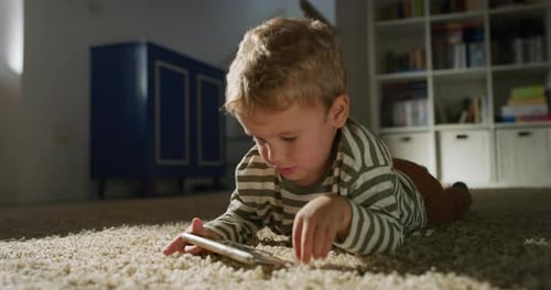 Child Lying on Carpet Using Mobile Phone