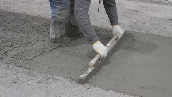 Construction worker in jeans, gloves, and boots stands knee-deep in wet ...