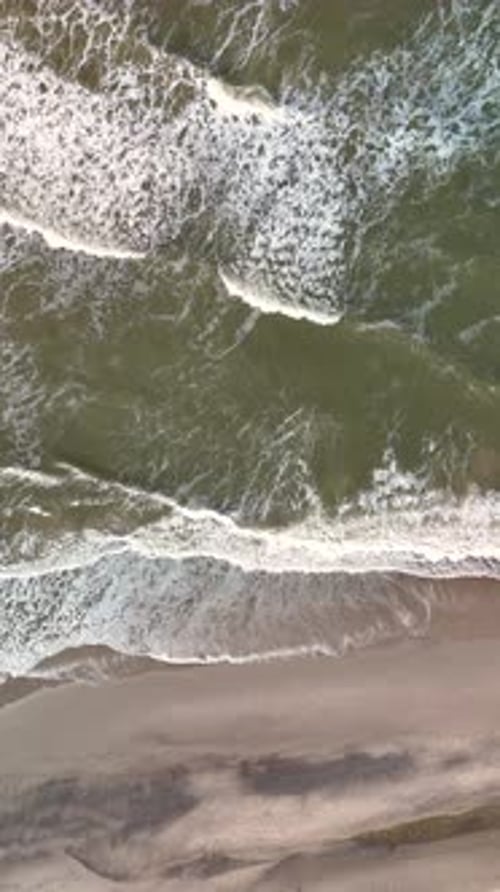 Waves Gently Crashing on the Sandy Shores of Lakolk Beach in Jutland Denmark Under Golden Sunlight