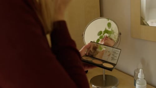 Woman Applying Makeup with Makeup Palette Indoors