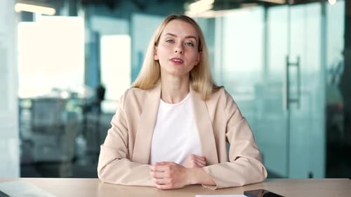 Webcam view Businesswoman in a suit watching video call training looking at camera while sitting