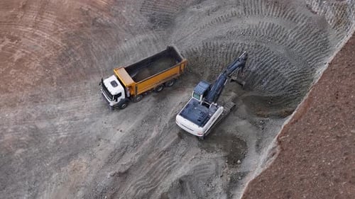 Excavator Filling Dump Truck in Rural Quarry