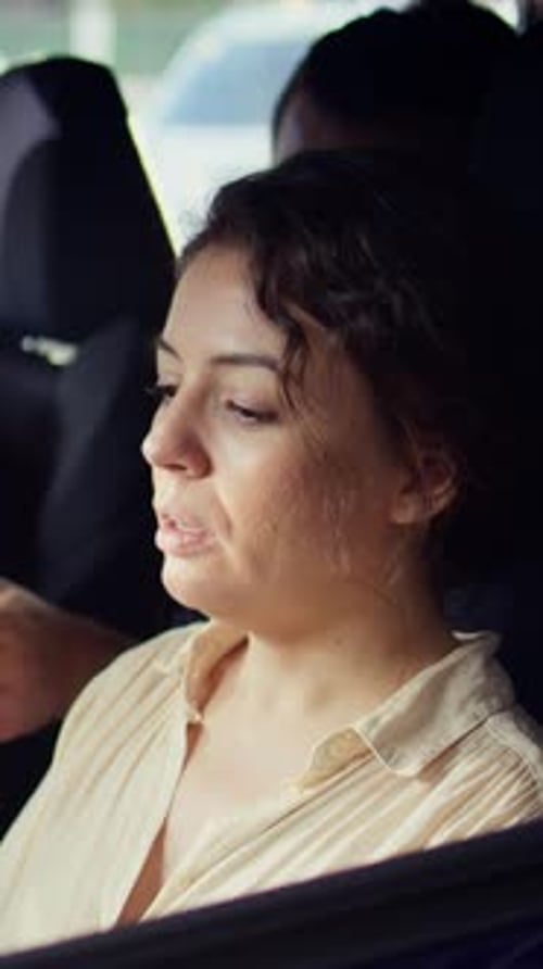 Woman Sits in Car Talking With Man Outside