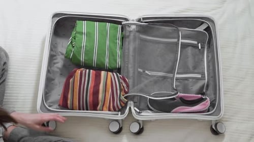 girl collects a suitcase for vacation, closeup top view