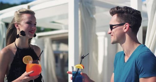 Couple Enjoying Cocktails by Pool at Resort Together