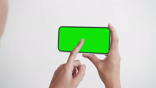 Young Woman Look and Use Tapping Touch Screen Phone with Green Chroma