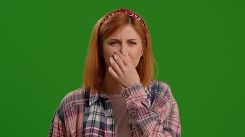 Woman reacting to bad smell on green screen
