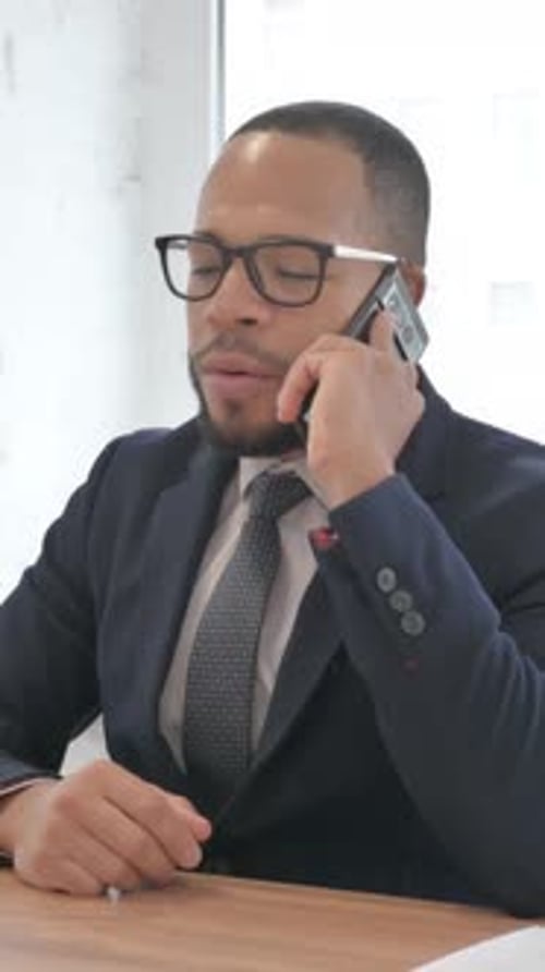 Mixed Race Businessman Talking on phone in Office, vertical video