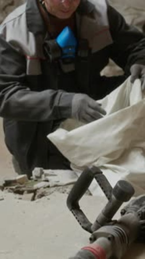Construction Worker with Jackhammer on Indoor Construction Site
