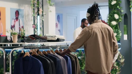 Man in Fashion Boutique Helped By Worker