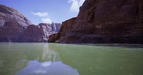 Serene River Landscape Surrounded By Towering Rock Formations During Daylight