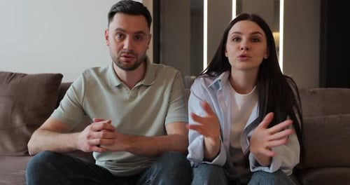 Man and Woman Talking on Couch Indoors