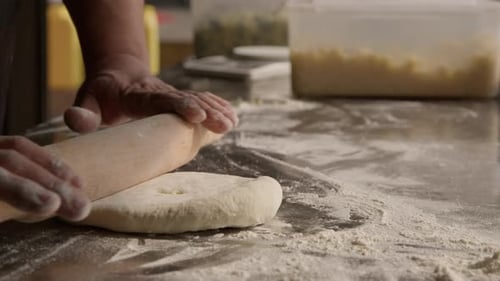 Preparation of the dough for pie, chef rolling dough using roll and flour
