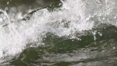 Water from a cold river moving down stream in slow motion and close up