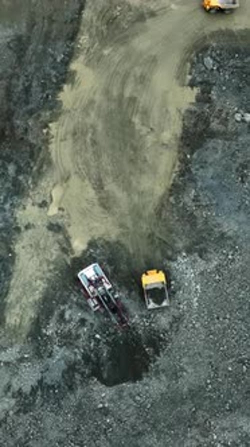 Yellow Dump Truck Unloading Gravel Into Quarry Stock Clip