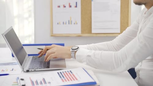 Businessman working on charts at his desk in the office.
