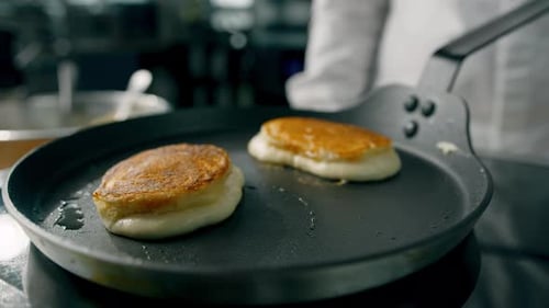 Pancakes with a crust are fried in a pan. Professional kitchen in the restaurant