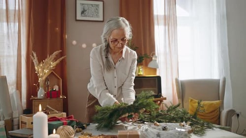 Senior Woman Making Christmas Wreath Indoors Daytime