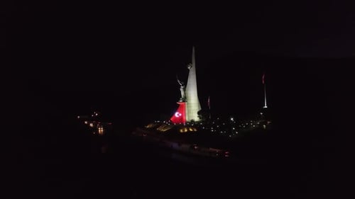 Vista noturna de drone da estátua de Manisa Ataturk e da cidade