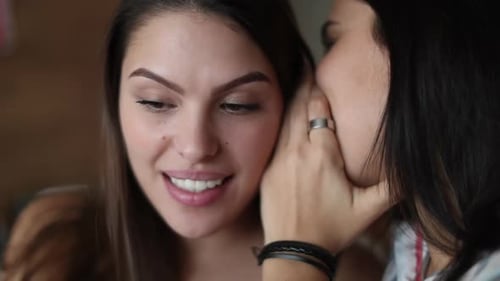 Friend sharing juicy gossip. Two girlfriends gossiping