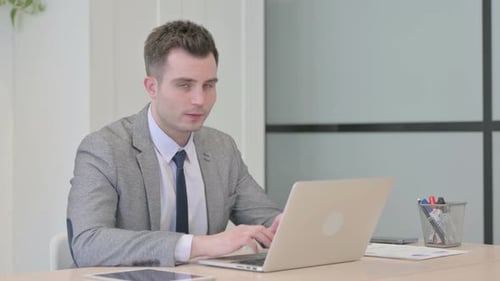 Man Working on Laptop at Office Desk