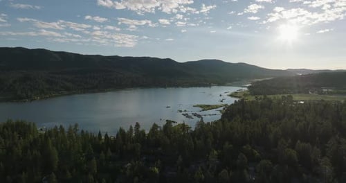 a body of water with trees and mountains in the background