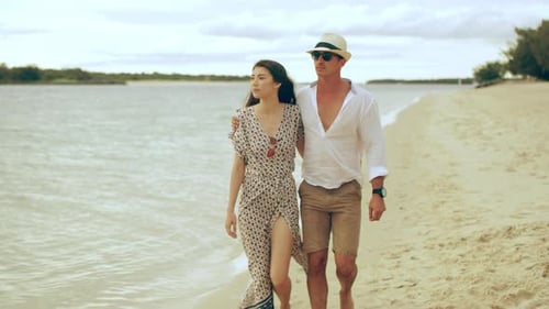 Young couple strolling along a beautiful australian beach at sunset
