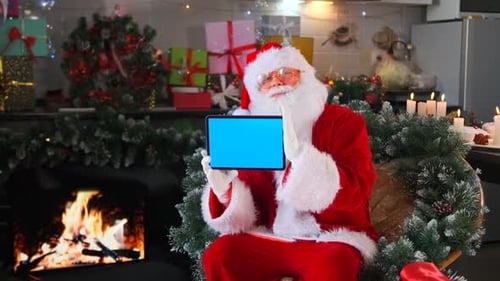 Santa sits with a blue screen tablet in his hands advertising Christmas discounts and sales