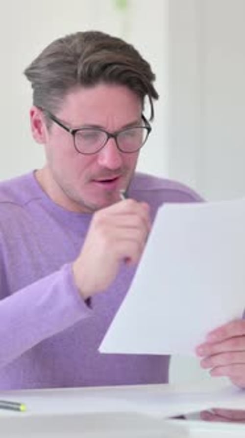 Man Reviews Documents and Reacts with Excitement