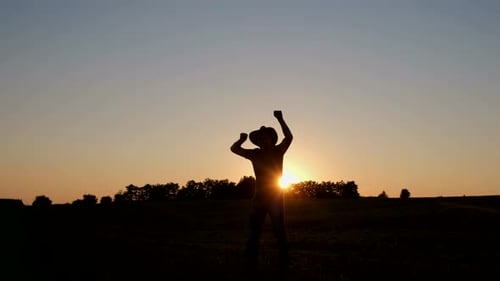 Silhouette of a Satisfied Farmer Performing a Funny Dance in the Field