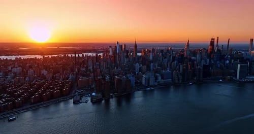 Orange sun setting above the scenery of New York.