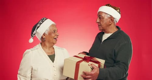 Gift box, surprise and senior couple with christmas tradition in studio for marriage together
