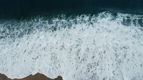 Vista aérea de las olas del mar chapoteando en la playa de arena