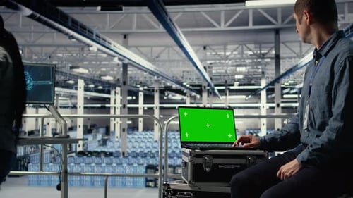 Los empleados del centro de datos comprueban el panel de inteligencia artificial con una computadora portátil con pantalla verde