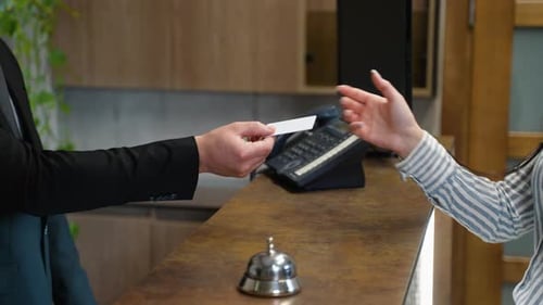 Hotel Receptionist Giving Room Key Card to Guest at Check in