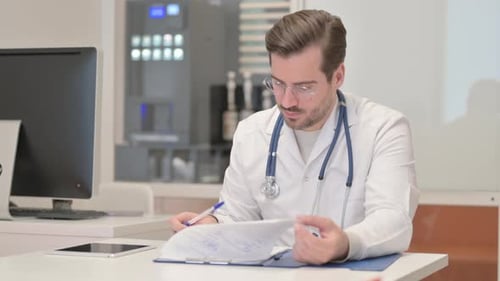 Young Doctor Working on Documents in Clinic