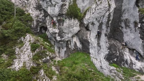 Group of climbers on a route, on a rock with belay via ferrata. Drone view of people in equipment