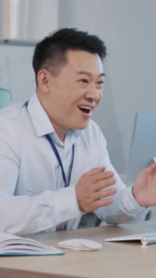 Enthusiastic Man Celebrates Achievement at Office Desk