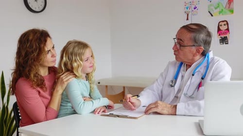 Pediatrician Talking with Mother and Child Girl at Doctor's Office