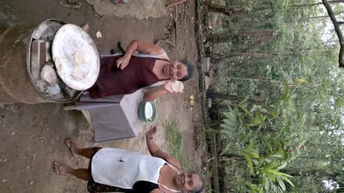 Two adult Hispanic women having fun while preparing corn tortillas