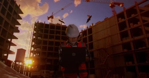 Asiatischer männlicher Ingenieur arbeitet auf der Baustelle an einem Laptop