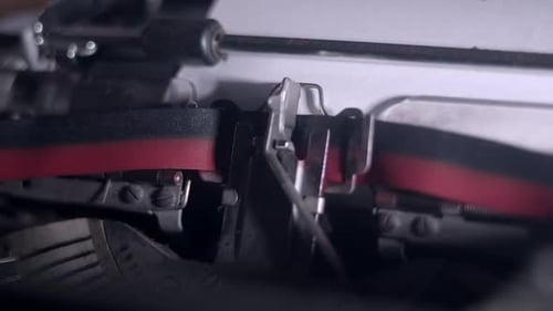 Typewriter types Top Secret onto blank page, close-up