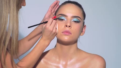 Makeup Artist Applies Makeup with Cosmetic Brush Beauty Visage Makeup Master with Young Beauty Model