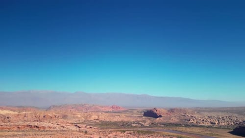 Aerial view drone flying over scenic mountains landscape with a clear blue sky.