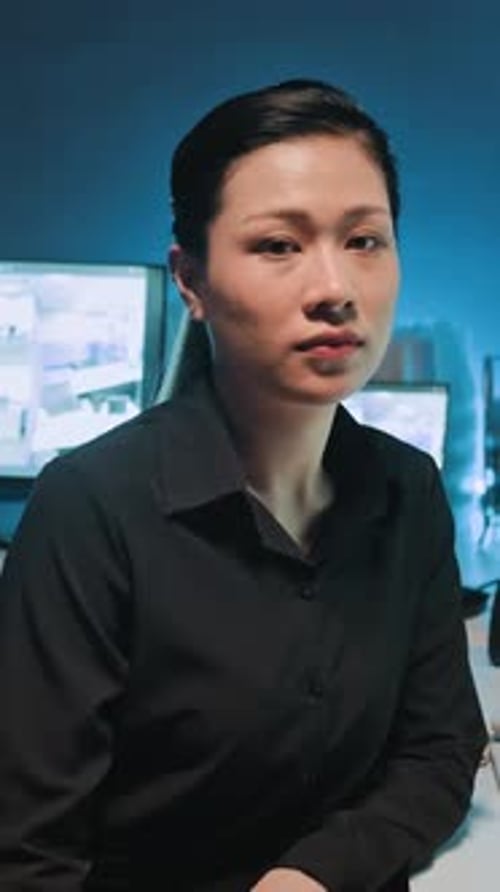 Portrait of Female Guard Sitting in front of CCTV Monitors