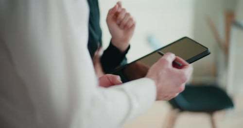 Man and Woman Reviewing Tablet in Office