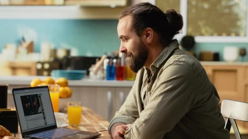 Man Watching Streaming Video with Live or Recorded Content on Laptop