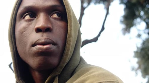 migrant africain triste et pensif avec capuche, gros plan