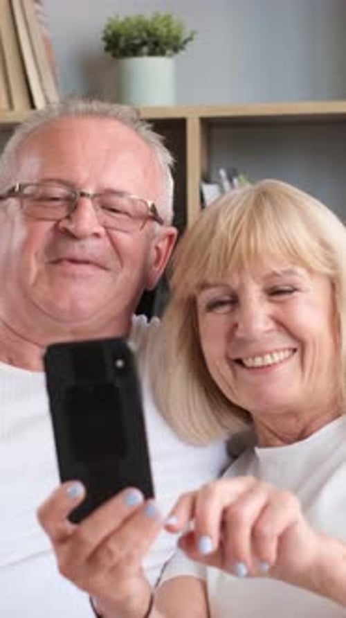 Senior Couple Smiling and Looking at a Phone