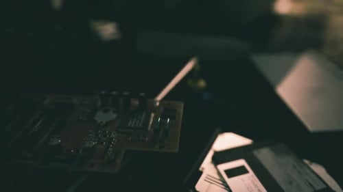 Dark Workspace Featuring Electronic Components and Vintage Media Materials